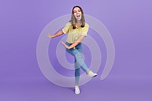 Full length photo of funky young brunette lady dance wear yellow top jeans shoes isolated on purple color background