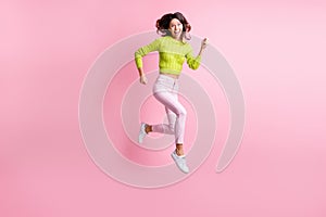 Full length photo of funny cute curly woman dressed green pullover jumping running isolated pastel pink color background
