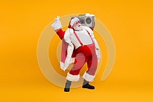 Full length photo of funny fat santa claus hipster with big belly hold boombox have fun listen christmas carols