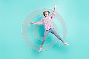 Full length photo of funny sweet young woman wear violet sweater waving arm jumping isolated turquoise color background