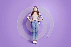 Full length photo of girl hands hips beaming smiling wear plaid shirt vintage headband jeans sneakers isolated purple