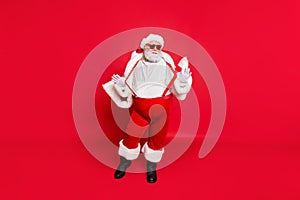 Full length photo of gorgeous white grey hair fat overweight santa in eyewear touch his suspenders feel cool wearing