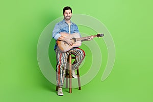 Full length photo of handsome attractive guy wear denim jacket enjoy guitar music empty space isolated green color