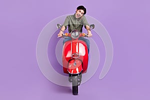 Full length photo of happy positive young man ride bike talk phone smile good mood isolated on violet color background
