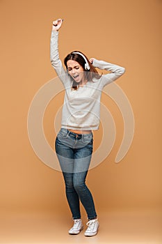 Full length photo of joyful girl in casual wear dancing while li