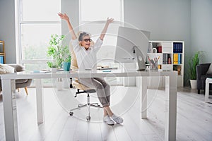 Full length photo of lawyer woman gray hair raised hands up celebrate overjoyed sitting chair work done  on home