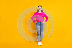 Full length photo of lovely girl hands hips look up empty space wear pink pullover jeans sneakers isolated yellow color