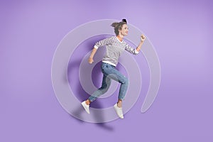 Full length photo of lovely slim lady dressed casual clothes jumping running  purple color background