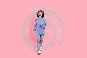 Full length photo of lovely young lady running forward dressed stylish blue knitwear garment isolated on pink color