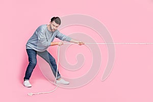 Full length photo of motivated guy ready pull string compete tug war isolated on pastel color background