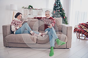 Full length photo of nice couple old lady man sit watch tv wear sweater jeans socks at home