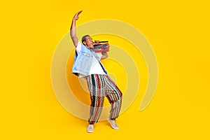 Full length photo of nice guy dressed jeans waistcoat hold boombox on shoulder look empty space logo isolated on yellow