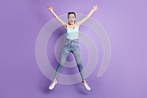 Full length photo of nice impressed brown hair lady jump yell wear top jeans isolated on purple color background