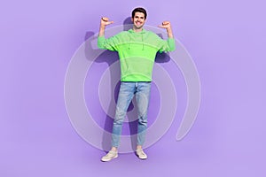 Full length photo of optimistic self confident guy green hoodie denim jeans directing at himself isolated on purple