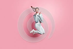 Full length photo portrait of amazed woman jumping up isolated on pastel pink colored background