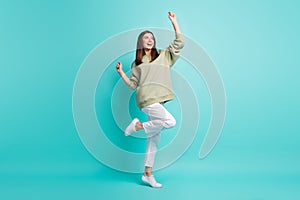 Full length photo portrait of carefree woman standing on one leg dancing reaching hands to the sky isolated on vivid