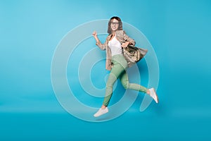 Full length photo portrait of cheerful girl running jumping up isolated on vivid blue colored background