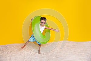 Full length photo of positive carefree little boy dressed white shirt going beach inflatable ring empty space 