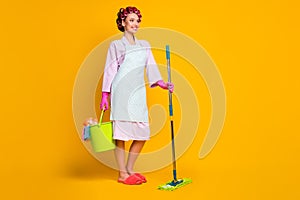 Full length photo of positive girl maid hold bucket mop wear gloves bath robe isolated bright color background