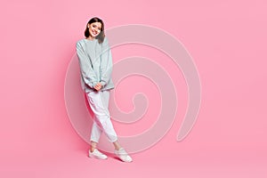 Full length photo of pretty milennial lady stand wear hoodie pants footwear isolated on pink background