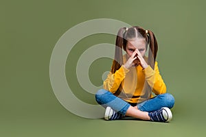 Full length photo of puzzled minded kid dressed yellow sweatshirt jeans sit think near empty space isolated on khaki