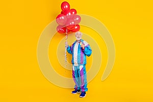 Full length photo of retired man body care workout inflate many balls decoration prize isolated over yellow color