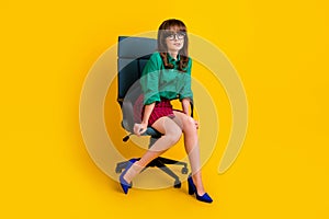 Full length photo of scared afraid woman dressed green shirt sitting armchair biting lip isolated yellow color