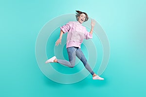 Full length photo of shiny excited young lady dressed purple pullover jumping waving arm isolated teal color background