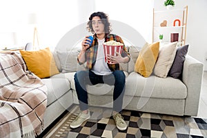 Full length photo of shocked funny guy dressed checkered shirt enjoying can cola pop corn watching intrigue movie