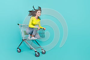 Full length photo of sweet brunette hair millennial lady ride in trolley look pomo wear top jeans shoes isolated on teal photo