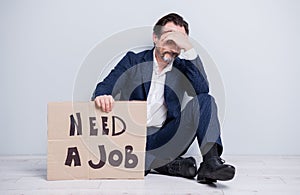 Full length photo of unhappy disappointed worker mature guy lost work jobless man hold carton placard seek work sit