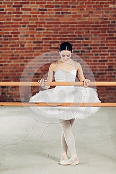 Full length photo. woman in white dress perforing ballet pose