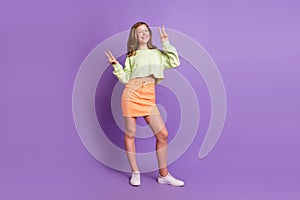 Full length photo of young cheerful girl happy positive smile show peace cool v-sign isolated over violet color