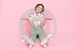 Full length photo of young girl happy positive smile shrug shoulders roller skater isolated over pastel color background