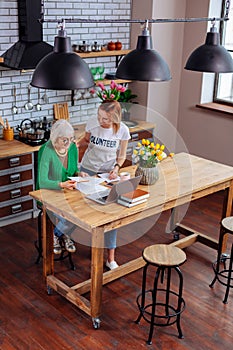 Full length photo of young lady discussing with granny papers