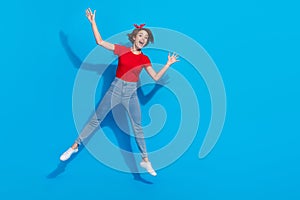 Full length photo of young lovely cheerful woman good mood jump ads isolated over blue color background