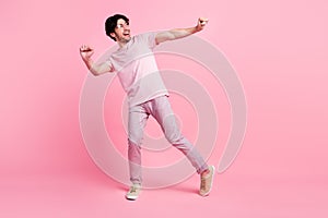 Full length photo of young man happy positive smile have fun dance party isolated over pink color background