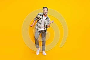 Full length photo of young man happy positive smile have fun dance party isolated over yellow color background