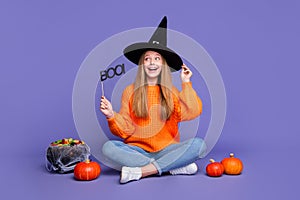 Full length photo of young positive teenager girl plate with boo word for halloween spooky holiday  on violet