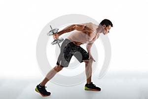 Full length photo of young sporty man exercising with dumbbell