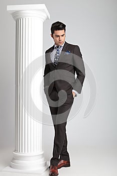 Full length picture of a young business man looking down