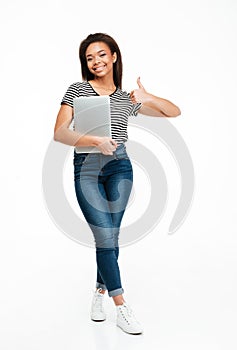 Full length portrait of a african teenager girl holding laptop