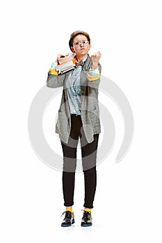 Full length portrait of a angry female student holding books isolated on white background