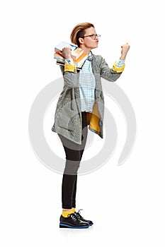 Full length portrait of a angry female student holding books isolated on white background