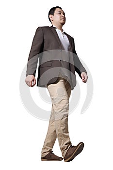 Full length portrait of Asian businessman wearing brown suit standing walking, side view low angle profile