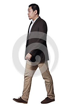 Full length portrait of Asian businessman wearing brown suit standing walking, side view profile