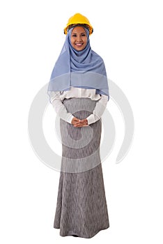 Full length portrait of asian muslim smiling woman engineer in blue hijab and yellow helmet, isolated over white background