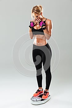 Full length portrait of a athlete woman standing on weights