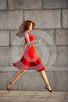 Full length portrait of attractive elegant young woman in red dress