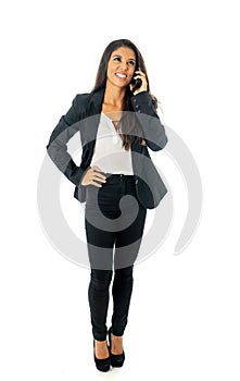 Full length portrait of Attractive latin corporate latin woman looking confident making a call on her mobile phone in Creative